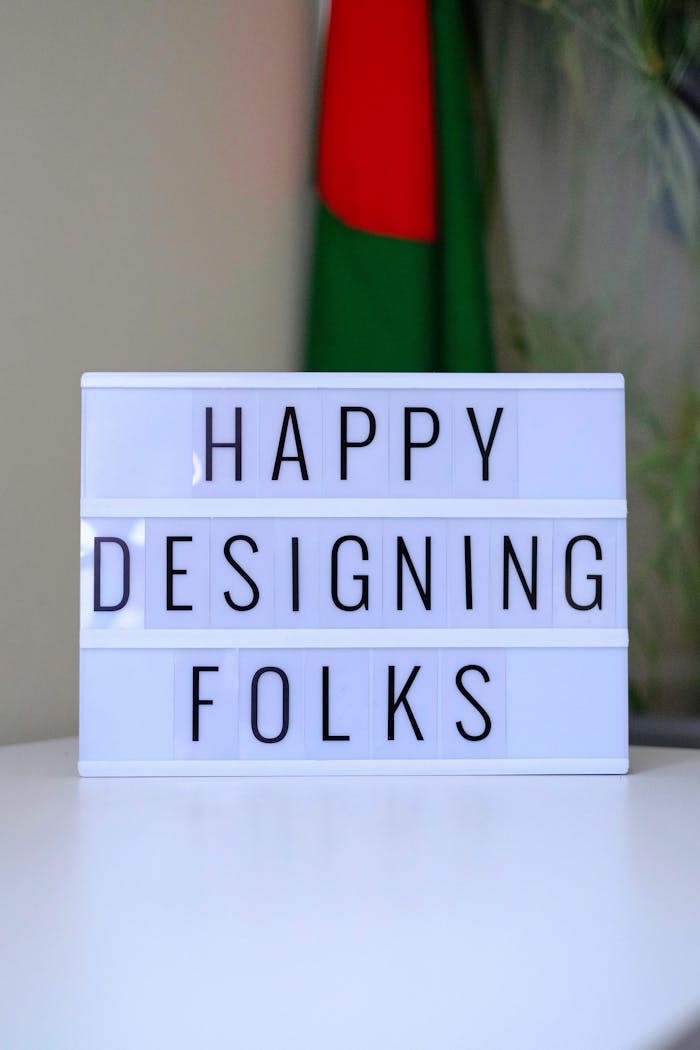 Lightbox sign displaying Happy Designing Folks in an office space.